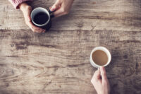 Podcastpersoner håller i kaffekoppar